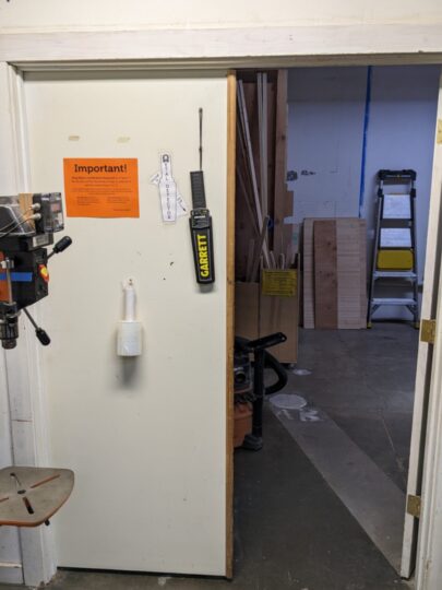 This shows the scanner hanging from a hook and cord on the back of a closed door.