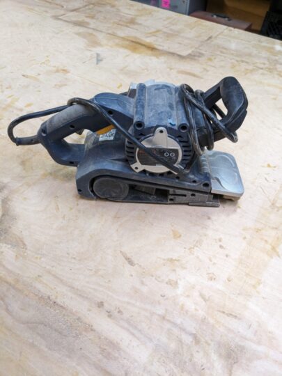 The belt sander wrapped in its power cord.